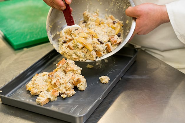 Pouring bread pudding into a baking dish 