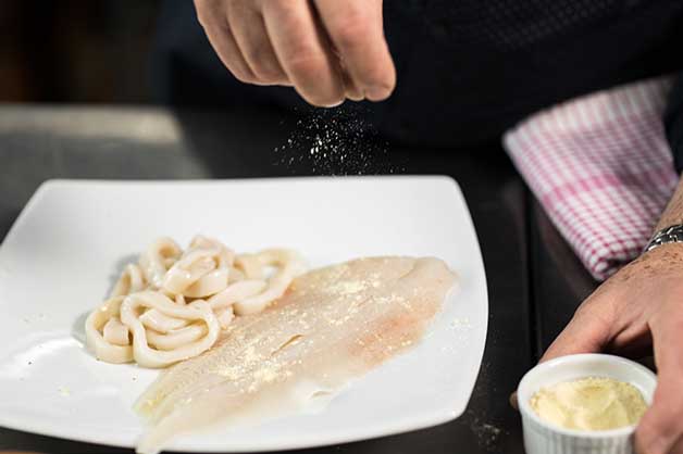 Image of the fish and calamari being seasoned