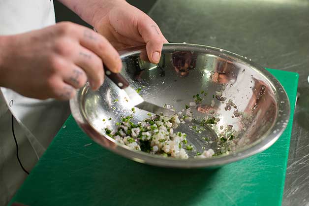 The chef is seen making the prawn tartare mixture