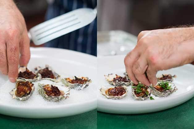 The chef finishes off the dish by adding parsley to each oyster
