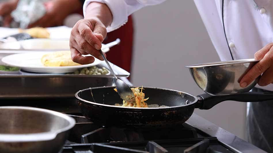 A chef is seen plating up a dish
