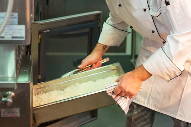 In this photo the chef is seen placing the rice in the oven
