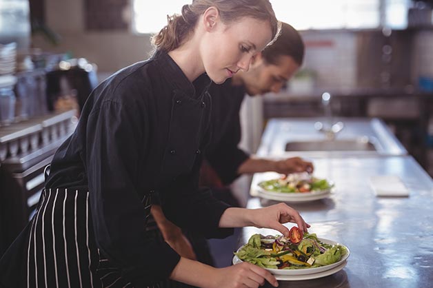 This shows two young female chefs working in the kitchen