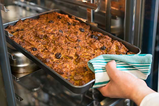 The Image Is Of A Gluten Free Bread Pudding Being Taken Out Of The Oven