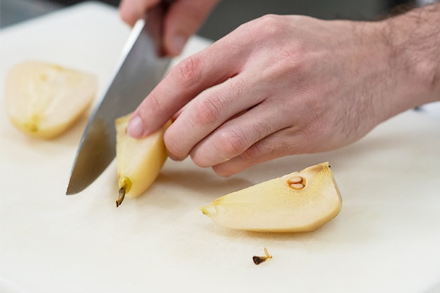 Slicing the poached pears once cooled
