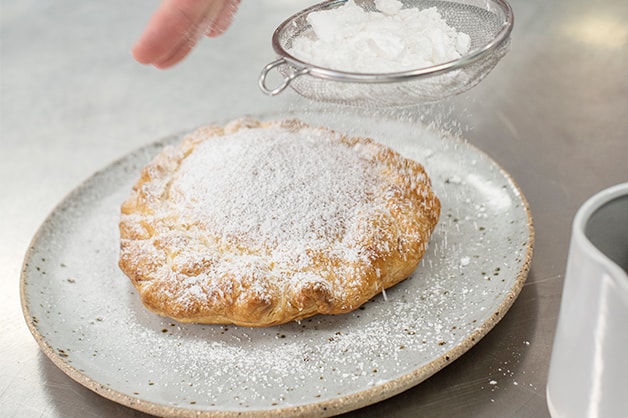 Dusting the pie with icing sugar