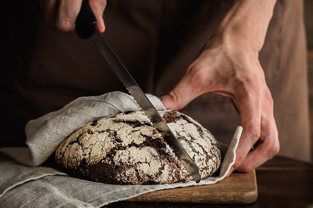 Image of a bread knife slicing through a loaf of bread
