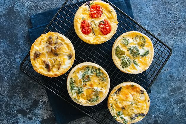 Five different tarts on a plate are pictured
