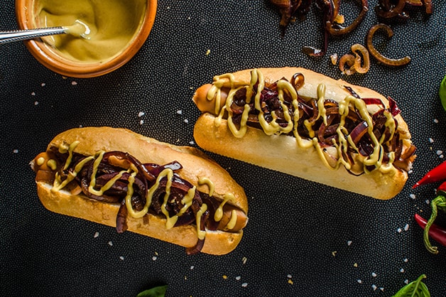 Photo of two hot dogs with onion
