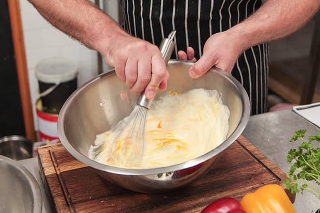 Chef is seen Combining White Wings Batter Mix and Eggs