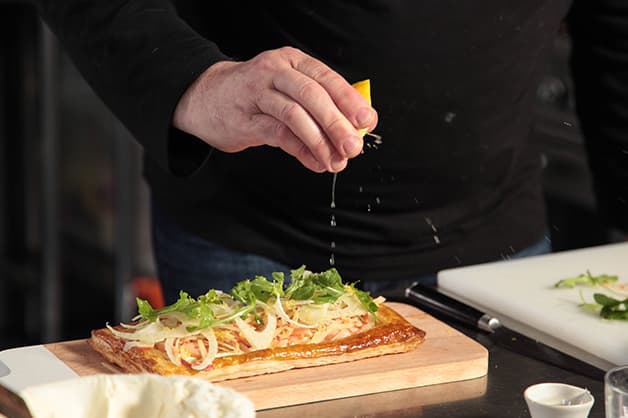 Image of the chef squeezing lemon juice over the tart