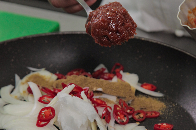 Adding chilli and paste to a pan